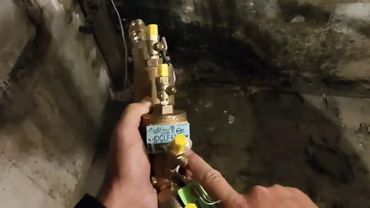 Plumber installing a backflow prevention valve assembly on a home's water line