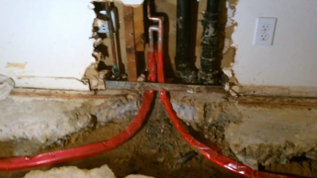 Plumber connecting a network of copper supply pipes during an installation