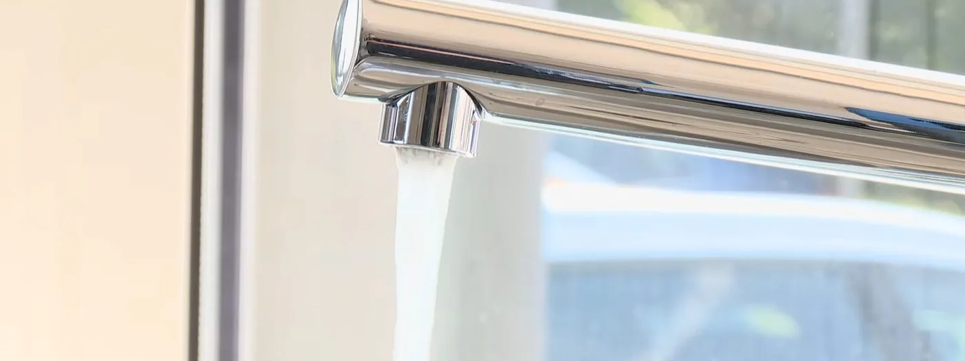 Close-up of a faucet aerator with mineral scale from hard water