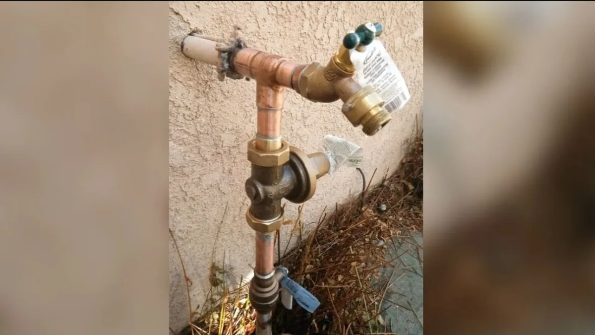 Plumber installing a frost-proof hose bib on a Coronado home's exterior