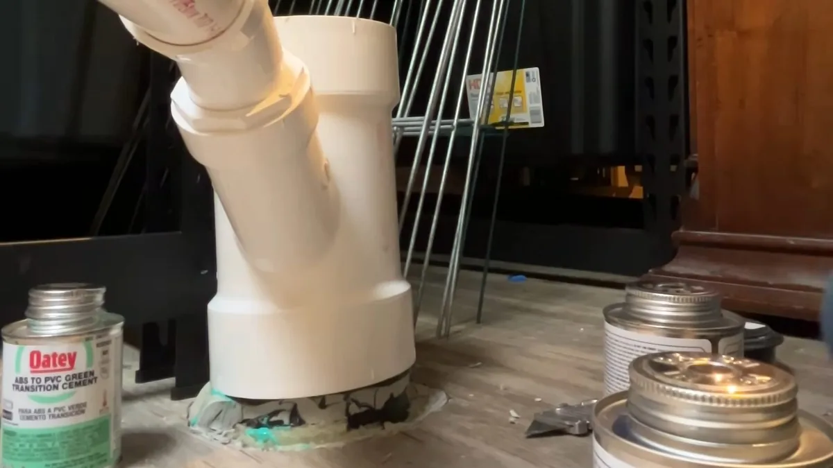 Plumber installing a garbage disposal unit beneath a kitchen sink