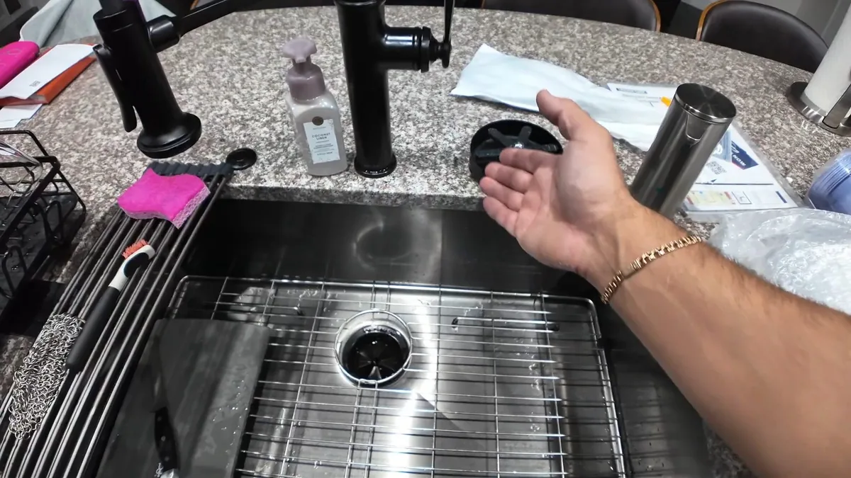 Plumber checking water flow at a kitchen faucet during a water quality visit