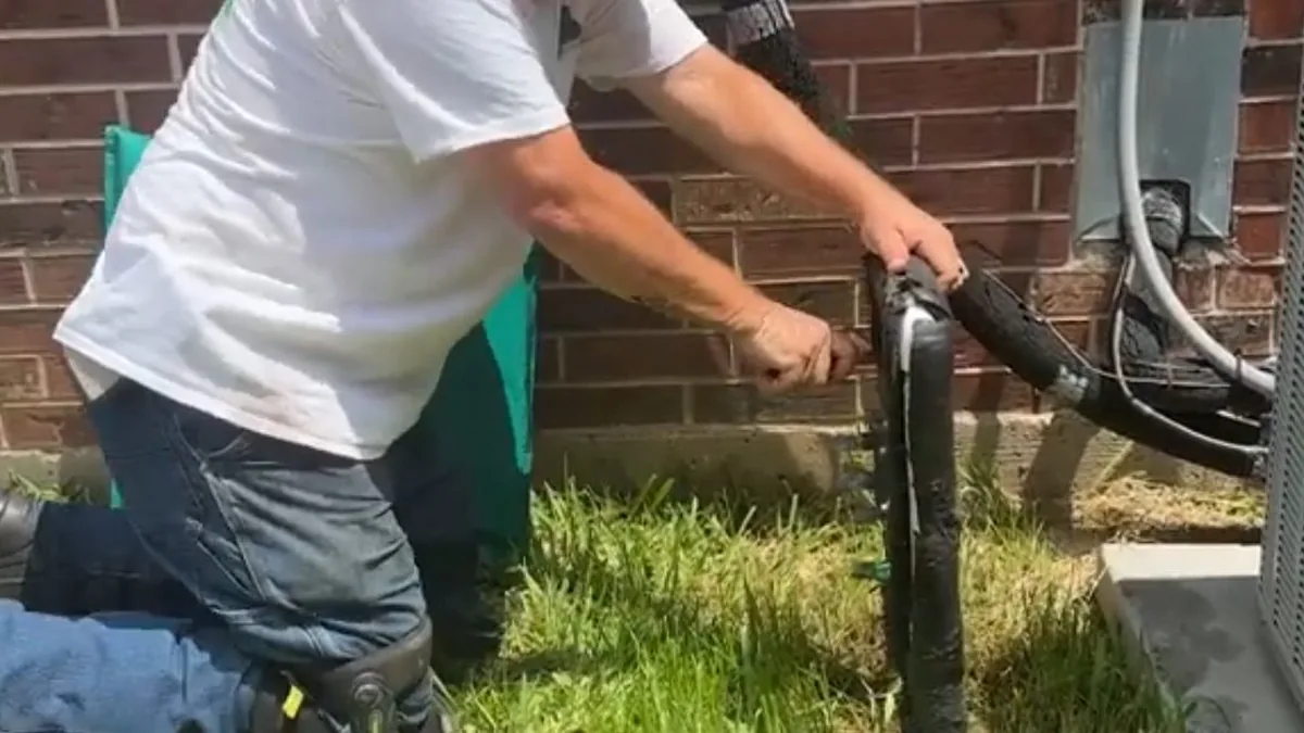 Plumber inspecting an exterior hose bib as part of a move-in plumbing check