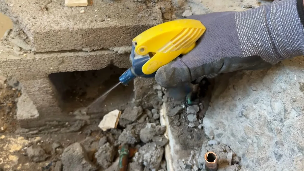 Plumber using leak-detection equipment to trace a hidden pipe leak