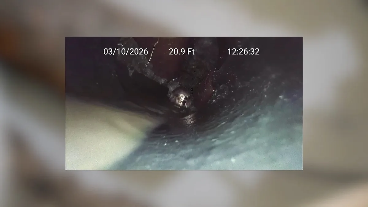Plumber viewing a sewer camera inspection feed on a monitor