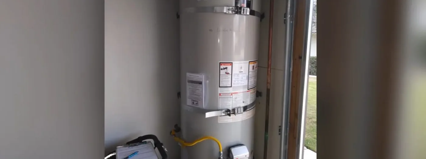 Wall-mounted tankless water heater unit installed in a utility space